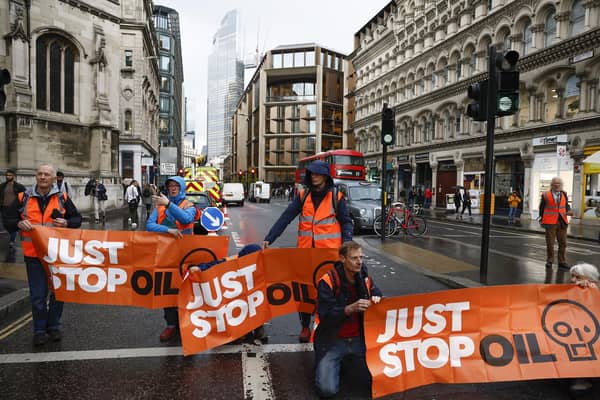 Just Stop Oil protesters block the road at the junction of Cannon Street and Queen Victoria Street in London on October 27 2022 in London, England. Photo by Jeff J Mitchell/Getty Images