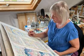 Patricia Haskey working in her Heysham studio on the painting of the Winter Gardens.