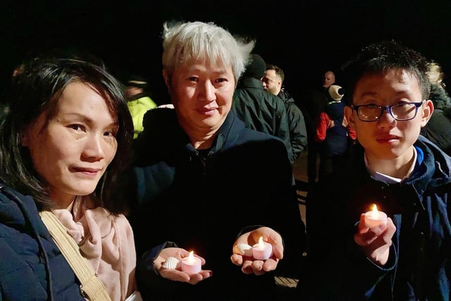 Members of the Chinese community with candles at the memorial event.