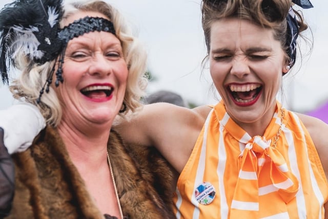 Two ladies in vintage clothing and headpieces laughing at the vintage festival. Picture by Robin Zahler.