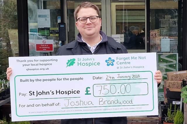 Joshua Brandwood outside St John's Hospice, Lancaster, with his cheque for £750.