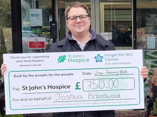 Joshua Brandwood outside St John's Hospice, Lancaster, with his cheque for £750.