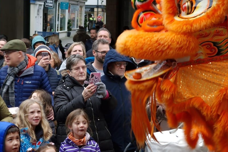 The crowd enjoys watching a colourful lion as it makes its way through Lancaster city centre.