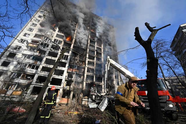 Firefighters extinguish a fire in a 16-storey residential building in Kyiv on March 15, 2022, after strikes on residential areas killed at least two people, Ukraine emergency services said as Russian troops intensified their attacks on the Ukrainian capital. - A series of powerful explosions rocked residential districts of Kyiv early today killing two people, just hours before talks between Ukraine and Russia were set to resume. (Photo by Sergei SUPINSKY / AFP) (Photo by SERGEI SUPINSKY/AFP via Getty Images)
