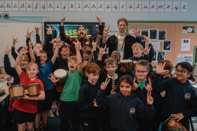 Massive Wagons frontman Baz and guitarist Adam with some of the Year 5 children at Dallas Road.
