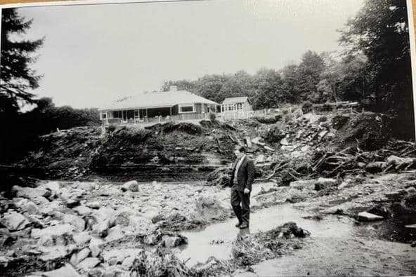 Wray Flood 1967. Villager Barton Brown surveys damage to the rock under Roeburn Scar bungalow. This was the home of the Everett family at this time. The raging water below the bungalow carried huge boulders but the bungalow remained untouched. Picture courtesy of David Kenyon.