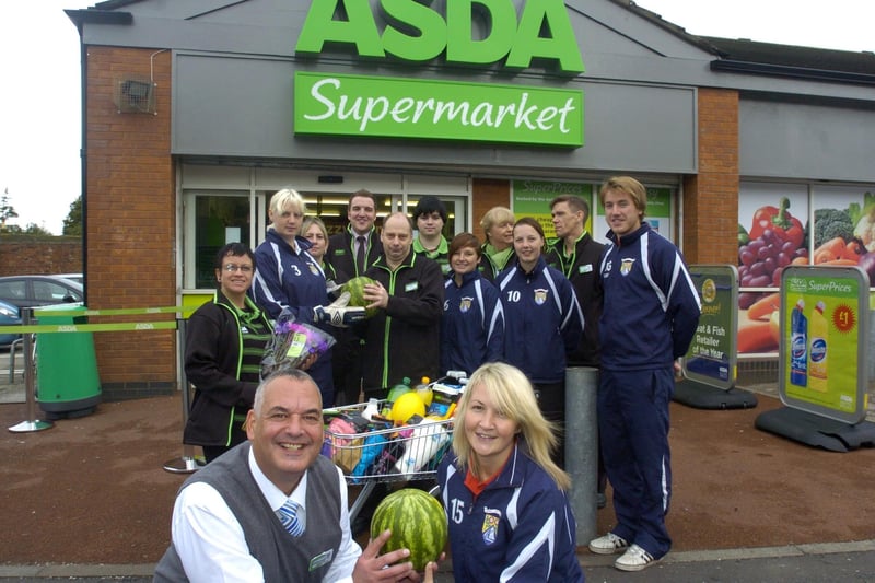 Store manager Gary Bartholomew opens the new Asda store at the former Netto store with the help of Sophie Fish (front), Jenny Keane, Sarah Gardner and Sammi Hindle and coach Robbie George from the Morecambe Ladies football team, watched by colleagues from the new Asda on Lancaster Road.
