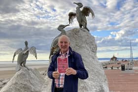 Author Lindsay Sutton shows his book at the entrance to Morecambe’s Stone Jetty.