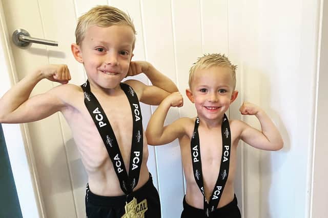 Jodie Flynn's two sons Cooper and Albie with their mum's medals for bodybuilding.