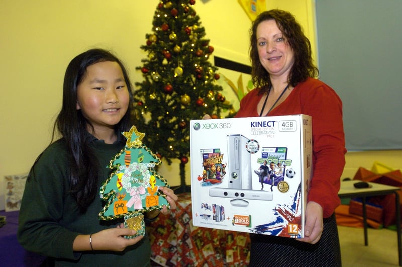 Sharron Forrest from Lancashire County Council presents Annelise Heywood, nine, from Scotforth St Paul's Primary School with an X Box 360 Kinect, which she won by designing the winning Christmas card in a card designing competition.