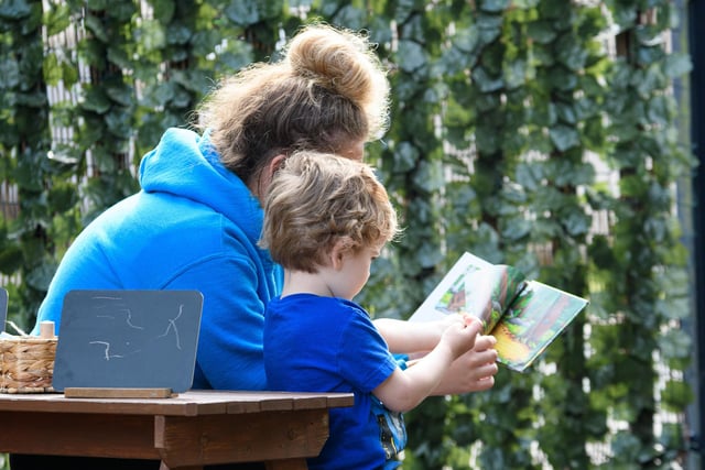 A nursery pupil reads a book.