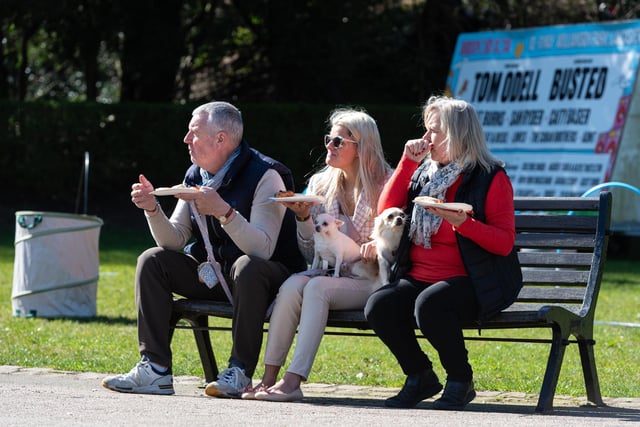 Three people and their dogs have a bite to eat at the Pups in the Park event in Williamson Park, Lancaster.