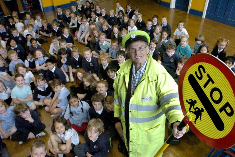 Retiring Dallas Road lollipop man, Ted Hopson, with children from Dallas Road Primary School at a special assembly to mark his 20 years' service.