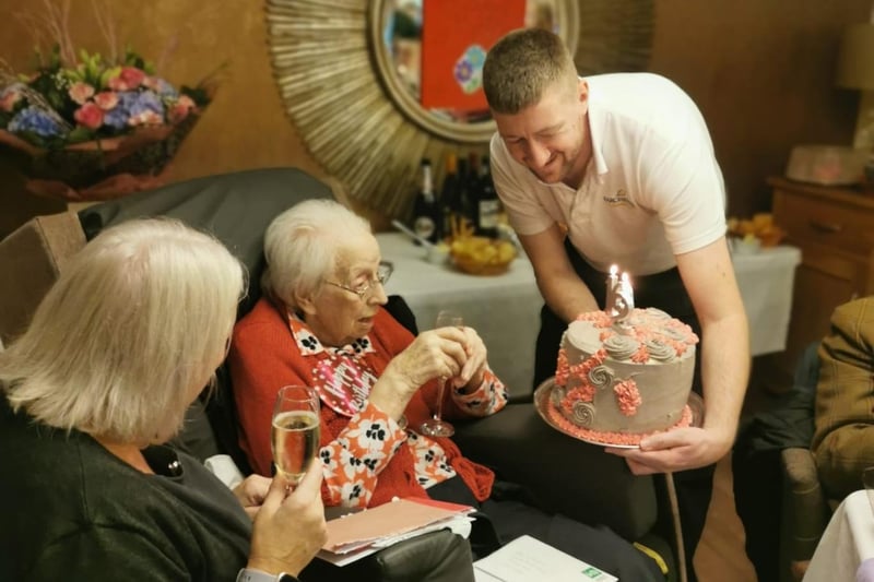 Manager Lyndsay, Sybil, and head chef Grant look at Sybil's birthday cake for her 102nd birthday.