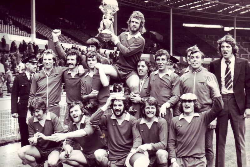 Morecambe FC players celebrate at Wembley with their FA Trophy in 1974.
