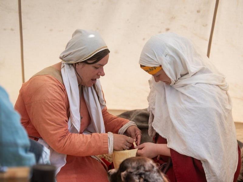 Heysham Viking Festival 2026 - two women doing traditional Viking crafts in the encampment.