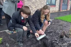 Schoolchildren from Garstang Community Academy buried a time capsule complete with mobile phone, newspaper of the day, 50 year predictions and lego at the official opening of the Meadow Croft care home in Garstang.