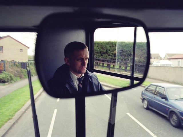 A Lancaster bus driver caught in the mirror by D J Clark in 2000.