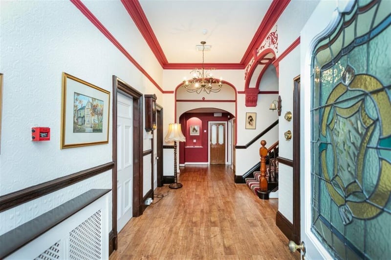 The spacious hallway has period features including cornicing and leaded glass in the door.