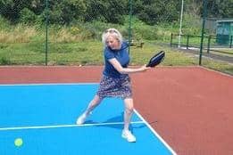 Sharon Phillips from CVS tries out the pickleball court at Lancaster Tennis Club.