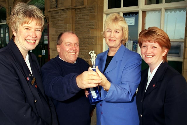 Ernest Keates from Crag Bank receives a miniature  pewter statue of Eric Morecambe as the 200,000th visitor to Morecambe Tourist Information Centre.  Presenting the statue are, from left, TIC assistant Julie Finnigan, tourism committee chairman  Coun June Ashworth and senior TIC assistant Deborah Hollings.