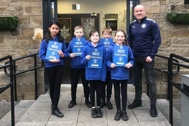 Director Dave Evans with children from Bowerham Primary school with their activity books. Picture courtesy of Lancaster City FC.