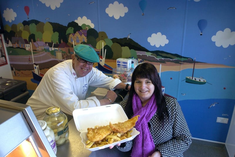 Reporter Michelle Blade with John Wild and the Chas Jacobs mural in Tarnbrook Chippy, Heysham