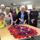 the proud knitters show off their handiwork to Lara McDonnell, centre back row, from FirstLight Trust. Picture: Ken Bennett