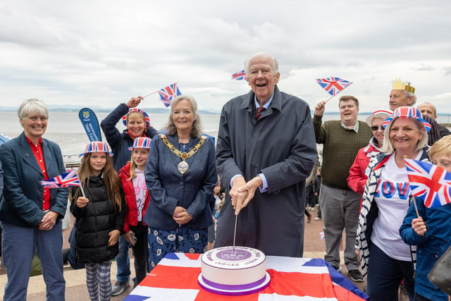 The Lord Lieutenant cuts the celebratory cake at the Queen's Platinum Jubilee record-breaking picnic attempt along Morecambe Promenade.