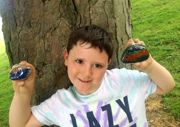 Isaac Murie with his painted pebbles.
