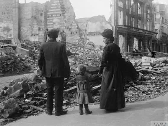 A refugee family returning to Amiens, looking at the ruins of a house, September 17, 1918.  IWM (Q 11341)