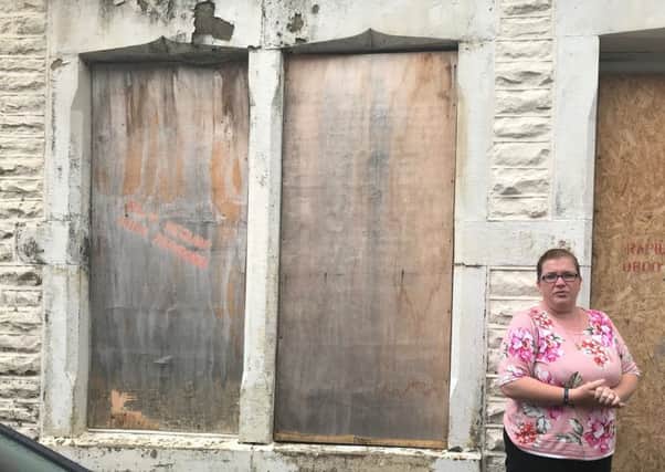 Katy Mitchell outside the derelict property next door to hers which has been boarded up for over six years.