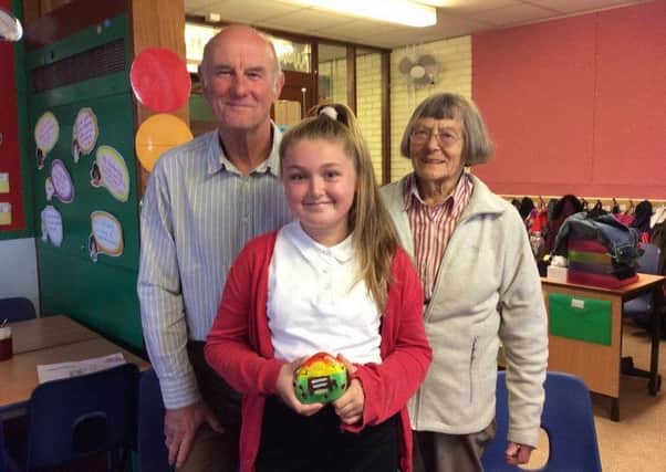 Ridge Primary School pupil Georgia Jackson with her winning pebble, with Jean Argles, Miss Whalley's great niece and Neil Tomlinson (Friends of Miss Whalley's Field committee member).