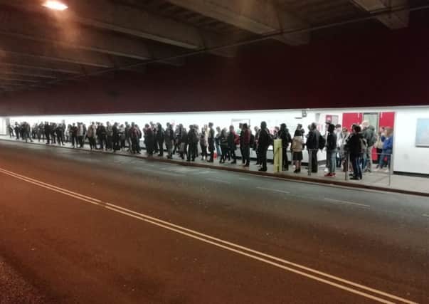 Students and staff queuin in the Lancaster University underpass for buses.