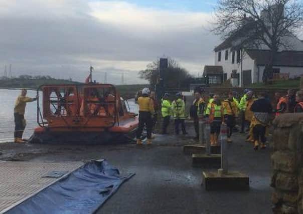 RNLI lifeboat volunteers and coastguard teams on scene at the launch site.
