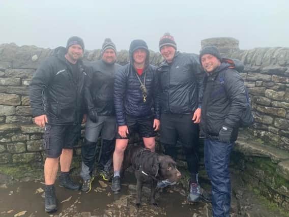 Michael Griffiths, David Redhead, Sam Nicholls, Adam Holt, Tom Smith and Bentley the chocolate Labrador, at the top of Ingleborough as they prepare for their challenge