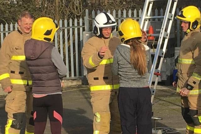 Firefighters help visitors to 'Have a Go' at their taster day.