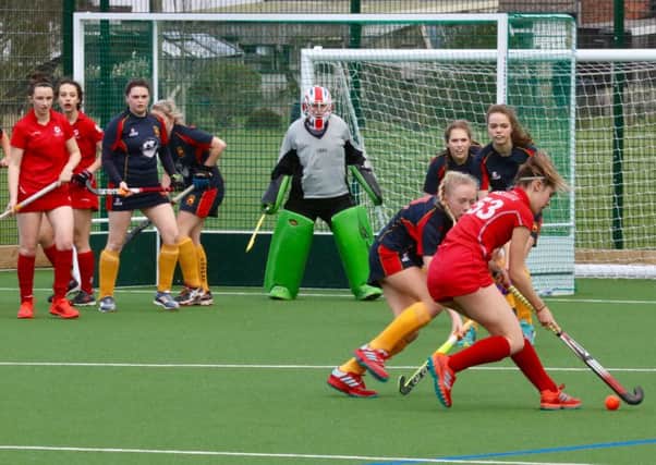 Garstang Hockey Club's Holly Hunter in possession as Rebecca Worthington and Summer Muirhead wait in front of goal
