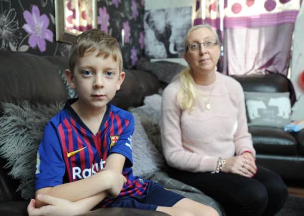 Seven-year-old Zac Harrison fractured his skull after a metal goal post fell on him.  He is pictured with mum Karen Harrison.