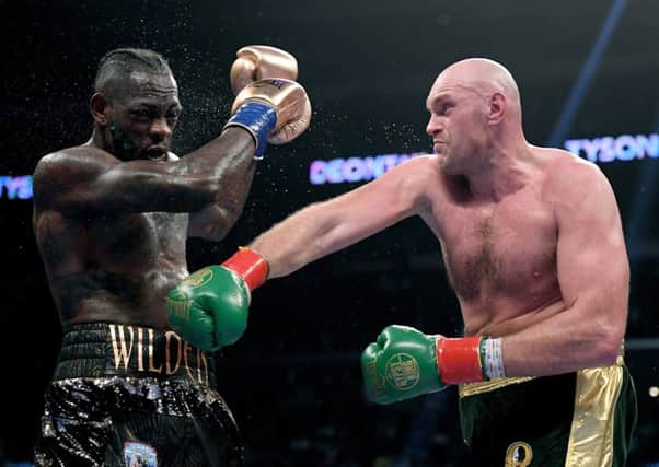 Tyson Fury punches Deontay Wilde in the seventh round fighting to a draw during the WBC Heavyweight Championship at Staples Center on December 1, 2018 in Los Angeles, California.  Photo by Harry How/Getty Images