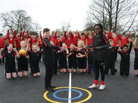 Year six pupils Max and Eniola  cutting the ribbon to officially open the MUGA along with other members of the schools Sports Council.