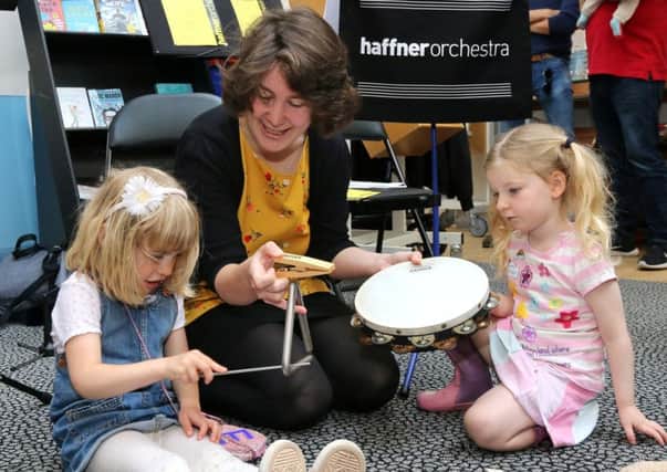 Emma Cordwell (left), and her friend Eily St John play with
percussion instruments after the event.
