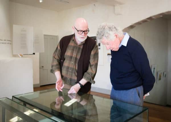 Poet Ian Duhig shows a visitor around the exhibition.