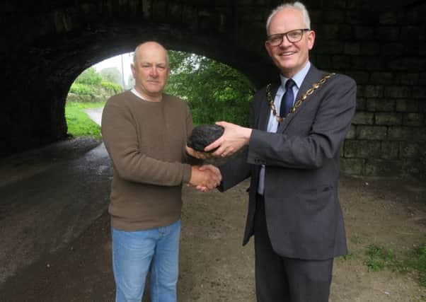 SLDC Chairman Councillor Stephen Coleman (right) is presented with the coal by Alan Roberts at Kendals canal path.