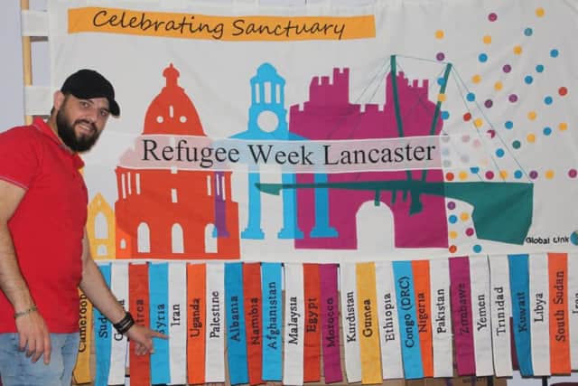 Refugee Bashar with the Refugee Week banner.