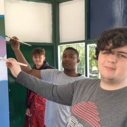 From left, Luke Cave Eastwood, Aaron Francis and Luke White work on the former bus waiting room on Central Drive, Morecambe, which has been turned into a hangout shelter for young people in the town