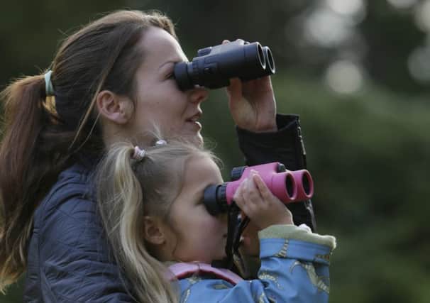 A family trying out binoculars at an RSPB Binocular and Telescope Open Weekend. Photo: rspb-images.com.