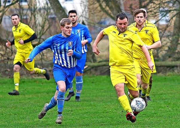 Caton United (yellow) take on Morecambe Royals (blue). Picture: Tony North