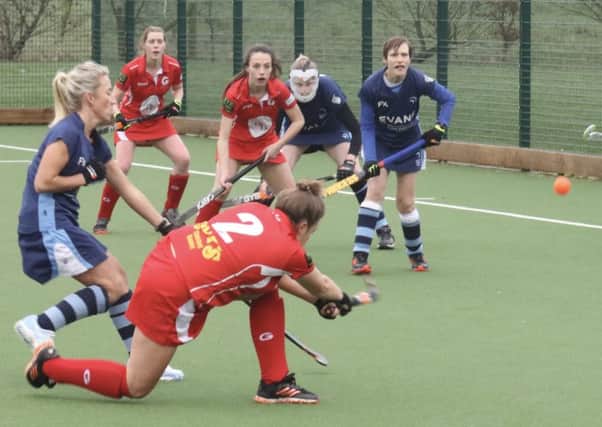 Garstang Hockey Club's Georgie Brumwell shoots with Summer Muirhead and Lyndsay Hayes in support