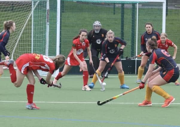 Garstang Hockey Club's Libby Baxter attempts to find Minnie Rogers and Summer Muirhead